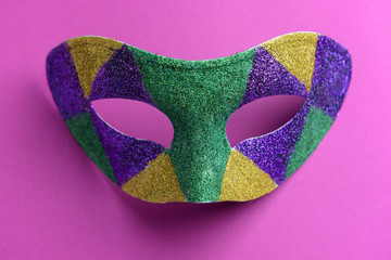 Festive mask on color background