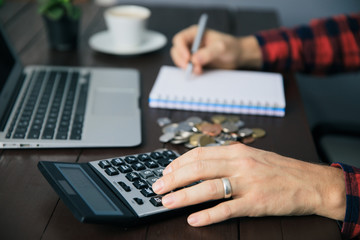 man hand coins with notepad and calculator