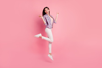 Full length side profile body size photo funny beautiful her she lady jump high show v-sign say hi wear shoes casual checkered plaid shirt white jeans denim clothes outfit isolated pink background