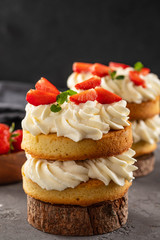 Victoria sponge cake with strawberries, jam and whipped cream on dark background. Copy space.