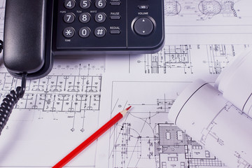 Engineering background. Construction drawings of buildings and structures next to phone and red pencil. Close-up.