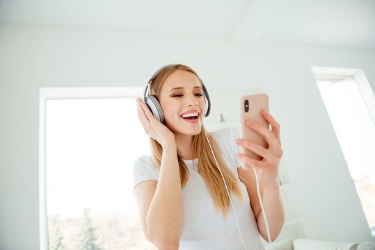 Close up photo of beautiful charming funny funky lady have holidays use user apps sing sound tracks headset laugh feel rejoice candid playful wear modern cotton clothing in apartment
