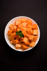 Cantaloupe / muskmelon / kharbuja cut into pieces, served in a bowl. selective focus