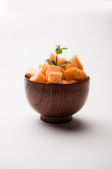 Cantaloupe / muskmelon / kharbuja cut into pieces, served in a bowl. selective focus