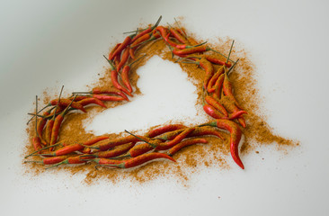 Close-up of Heart, symbol of love, designed from red hot chili cayenne peppers handful with paprica powder