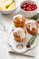Muffins, cakes with cranberry and lemon on a white board.