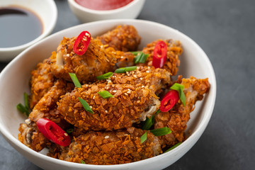 Chicken nuggets with sauce and pepper on a dark background. Copy space.