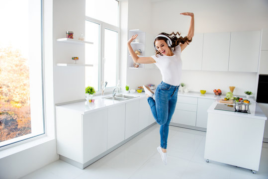 Full length body size view portrait of her she nice attractive crazy childish playful girlish cheerful cheery wavy-haired girl having fun in modern light white interior style room