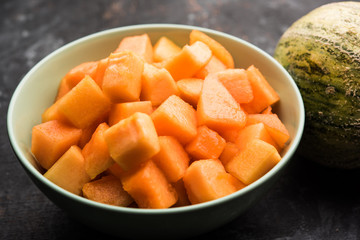 Cantaloupe / muskmelon / kharbuja cut into pieces, served in a bowl. selective focus