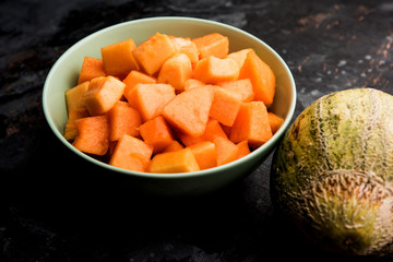 Cantaloupe / muskmelon / kharbuja cut into pieces, served in a bowl. selective focus