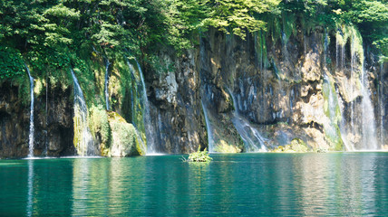 Waterfalls and hill, beautiful nature landscape, Plitvice Lakes in Croatia, National Park, sunny day