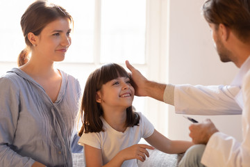 Fototapeta premium Paediatrician stroking patient girl encourages her before medical examination