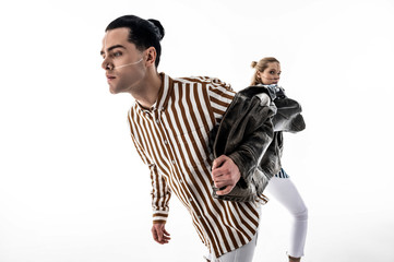 Man wearing striped shirt taking jacket from colleague while posing