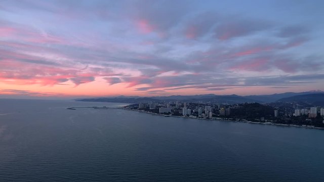 Aerial city coastline from drone in sea during sunset. Super wide shot.