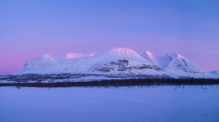 The famous mountain Ahkka, sometimes called the queen of Lapland, in the last sunlight of a winters day. Lapland, Sweden.