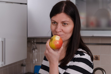 A young girl eats an apple.