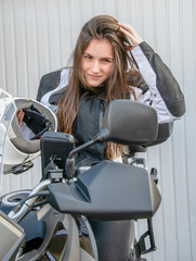 Chica arreglándose el pelo tras un viaje en motocicleta.