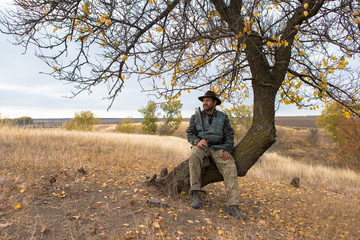 Hunter with a hat and a gun in search of prey in the steppe	