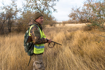 Hunters with a german drathaar and spaniel, pigeon hunting with dogs in reflective vests	