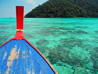 The colorful of the head long tail boat that running through the turquoise sea.