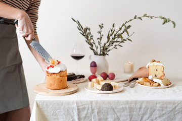 Cut easter cake in womans hand. Easter traditional orthodox sweet bread, kulich. Easter holidays breakfast. Female cutting Easter cake