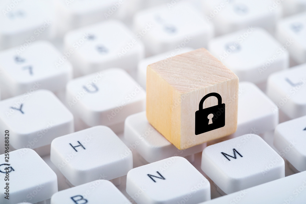 Poster wooden block with lock graphic on computer keyboard. computer security concept.