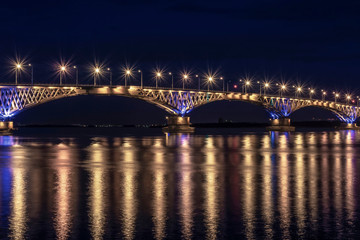 Fototapeta na wymiar a fragment of an automobile bridge across the Volga River at night lit by lanterns, Saratov Russia