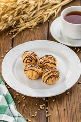 Tasty profiteroles with cream and chocolate glaze on wooden table