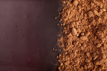 Pile of cocoa on chocolate background.