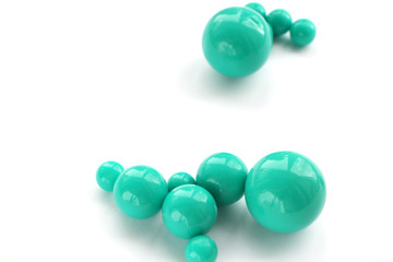 Abstract background of plastic green beads of different size on a white background. copy space...