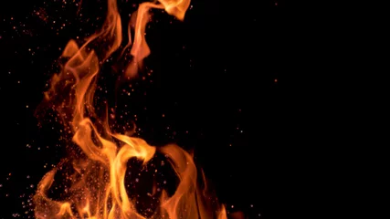 Foto op Plexiglas Vuur MACRO: Prachtige feloranje vlammen flikkeren in de duisternis van de nacht.