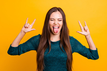 Close up photo beautiful amazing her she lady arms hands fingers hard rock symbol behavior leisure tongue out mouth wear jeans denim green knitted pullover jumper isolated yellow background