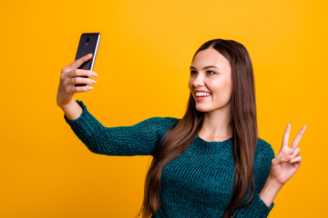 Close up photo beautiful her she lady hold arm hand telephone make take selfies show fingers v-sign symbol say hi blog followers wear green knitted pullover jumper isolated yellow background