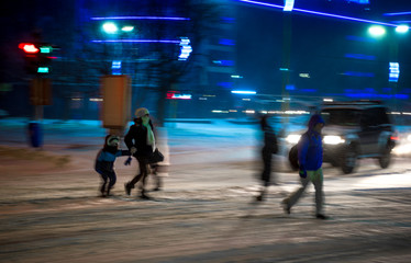 Busy city street people on zebra crossing at night in winter