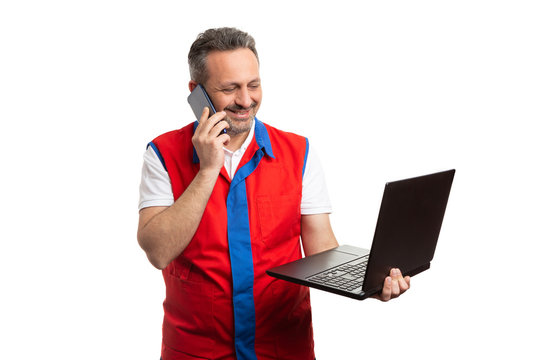 Supermarket Employee Talking On The Phone And Holding Laptop.