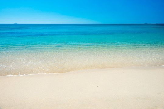 Beautiful horizon view of tropical sea and sand beach under blue sky