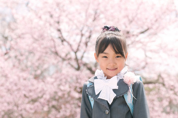 桜の前で微笑む小学生