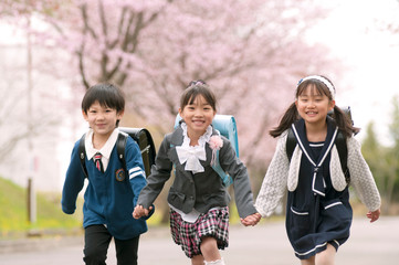 桜並木道を走る小学生
