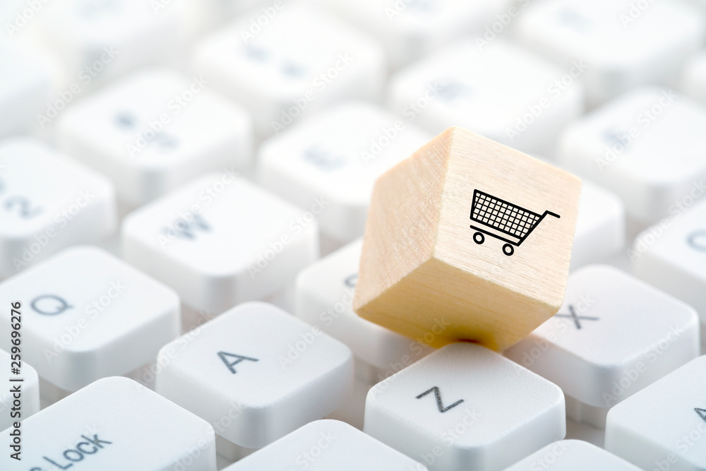 Poster wooden block with shopping cart graphic on computer keyboard. online shopping concept.