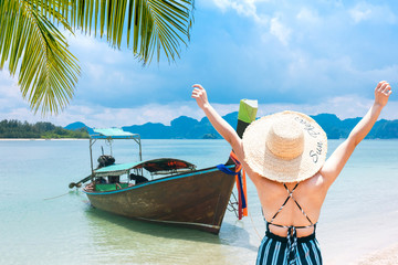 Fototapeta na wymiar woman with straw hat on the beach on a sunny day