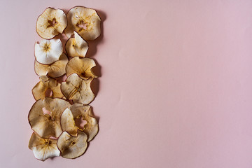dried apples chips over red background.