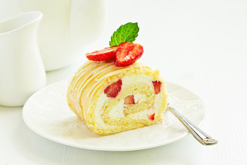 A piece of biscuit roll with cream and strawberry.