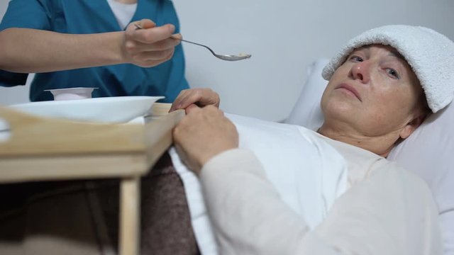 Terminally ill female patient refusing from meal, sad woman suffering disease