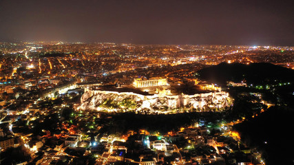 Aerial drone night shot of iconic illuminated landmark Acropolis hill and the Masterpiece of...