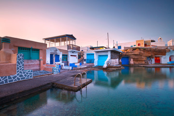 Fototapeta na wymiar Boat houses in the harbour of Mandrakia village on the northern coast of Milos island.
