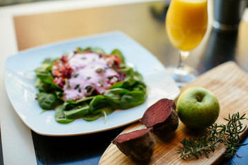 Salad with orange juice beside. 