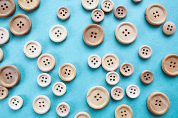Fototapeta premium many large and small beige wooden buttons on blue background