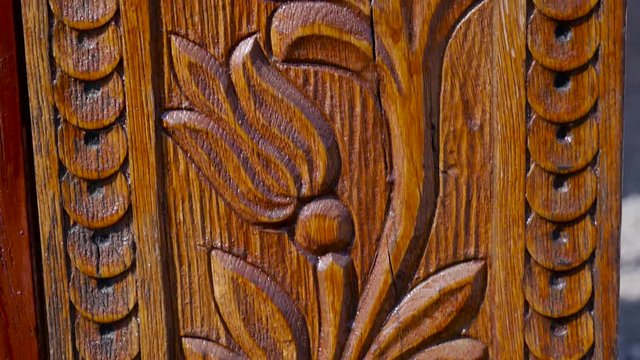 Detailed hand carved flowers on traditional hungarian oak wood gate pylon . 