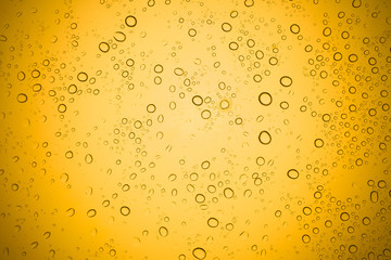 Water drops on yellow glass, Rain droplets on glass background.