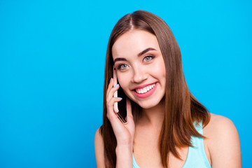 Fototapeta premium Close up photo beautiful amazing she her lady toothy hold hands arms telephone smart phone look side empty space tell foreign boyfriend wear casual tank top outfit clothes isolated blue background